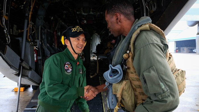 U.S. Marine Corps Capt. Brandon Thompson, a MV-22B Osprey tiltrotor aircraft pilot from Marine Medium Tiltrotor Squadron 262, 31st Marine Expeditionary Unit, shakes hands with a Japan Maritime Self-Defense Force pilot from the Fleet Air Wing 22 at Oruma Air Base, Nagasaki, Japan, Nov. 18, 2016. The aircraft flew from the island of Okinawa, conducted simulated humanitarian aid with the JMSDF at multiple locations and was refueled by JMSDF personnel before returning to Okinawa. The aircraft also conducted a passenger exercise carrying Sasebo Mayor Norio Tomonaga and the Assemblymen of Defense for Sasebo City. 