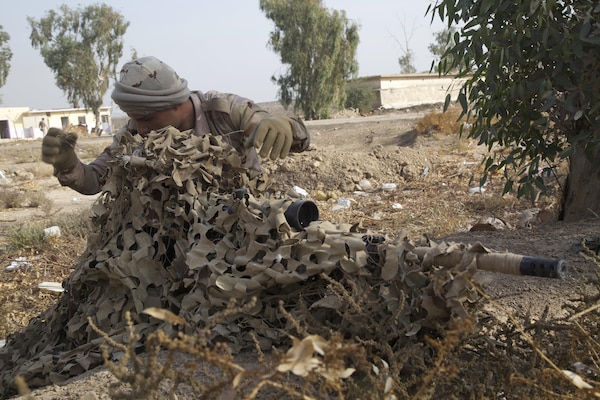 Iraqi soldiers, acting as a fire team, utilize their environment to camouflage themselves during stalking training at Camp Taji, Iraq, Nov. 16, 2016. This training is critical to enabling the Iraqi security forces to counter Da’esh as they work to regain territory from the terrorist group. (U.S. Army photo by Spc. Craig Jensen)
