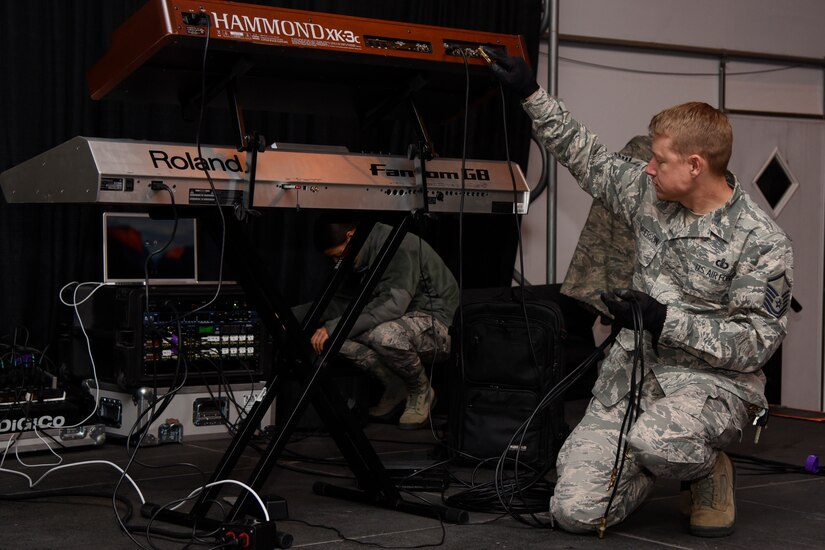 Master Sgt. Jonathan McPherson, U.S. Air Force Band Max Impact director and pianist, sets up before a performance at the FedEx Field in Landover, Md., Nov. 20, 2016. The band setup an electronic keyboard, a drum set and an electric guitar. The band performed before the Washington Redskins military appreciation game. (U.S. Air Force photo by Airman 1st Class Valentina Lopez)