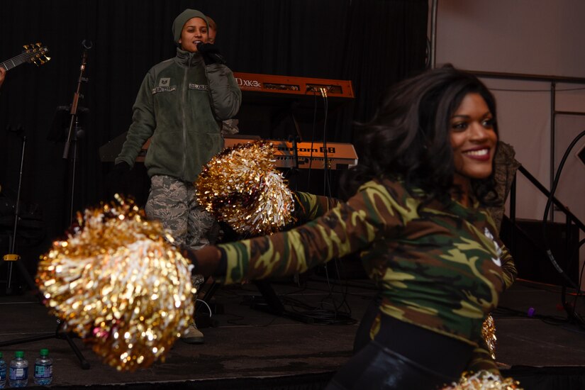 Tech. Sgt. Nalani Quintello, left, U.S. Air Force Band Max Impact vocalist, performs alongside the Washington Redskins’ cheerleaders at the FedEx Field in Landover, Md., Nov. 20, 2016. The band performed before the Washington Reskins military appreciation game. (U.S. Air Force photo by Airman 1st Class Valentina Lopez)
