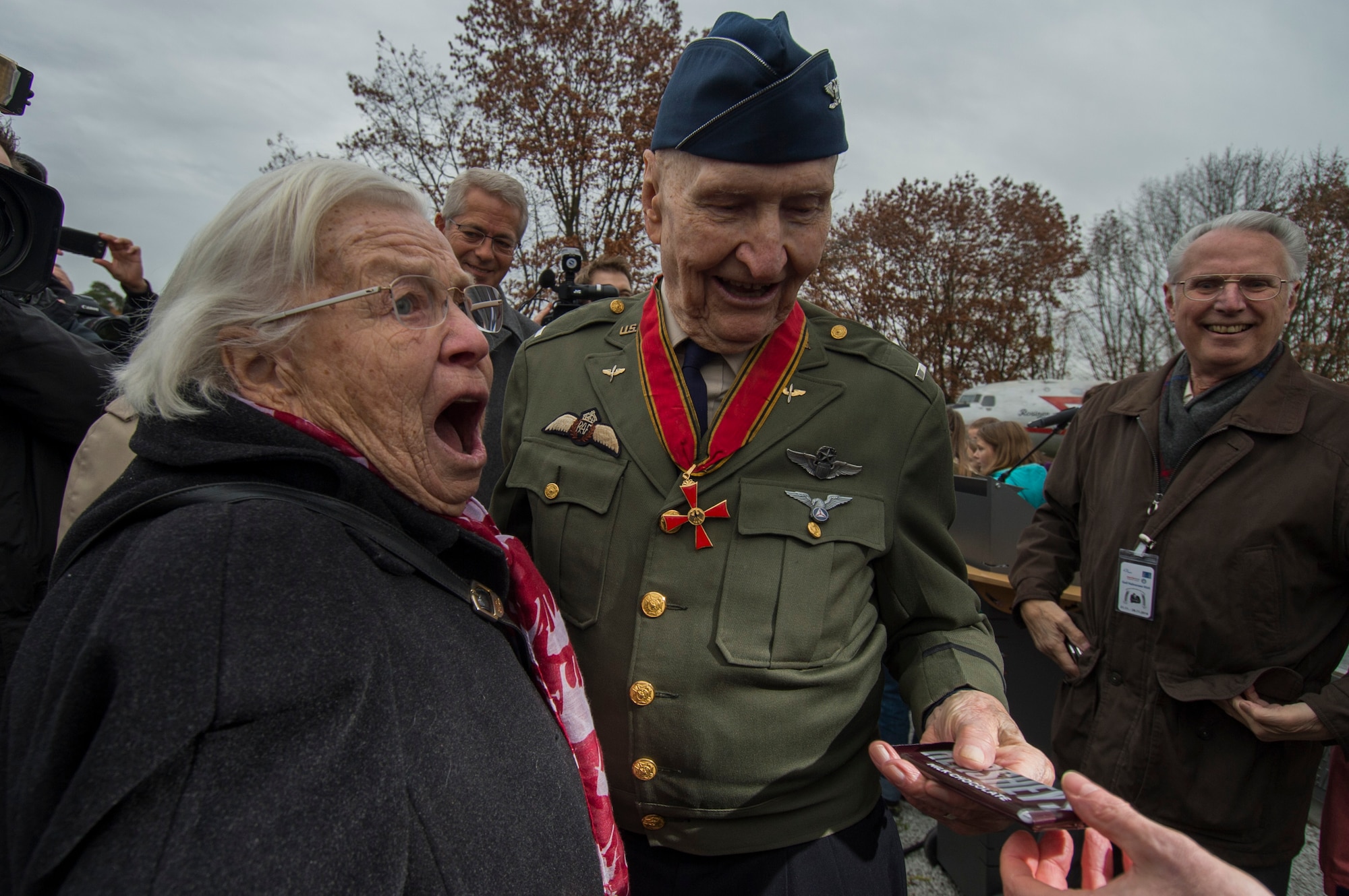 Retired U.S. Air Force Col. Gail Halvorsen, a C-52 Skymaster pilot also known as the Candy Bomber, prepares to present a chocolate bar to Gisela Rainare, a former civilian employee at the former Frankfurt an Main Air Base, Germany, before the reopening ceremony of the Berlin Airlift Memorial outside Frankfurt International Airport, Germany, Nov. 22, 2016. Halvorsen and his fellow pilots dropped 23 tons of candy with makeshift parachutes from his C-54 as part of the Berlin Airlift, which delivered more than two million tons of food to the blockaded citizens of West Berlin between June 1948 and September 1949. (U.S. Air Force photo by Staff Sgt. Joe W. McFadden)