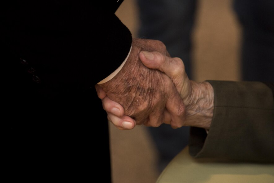Retired U.S. Air Force Col. Gail Halvorsen, a C-52 Skymaster pilot also known as the Candy Bomber, shakes hands with a German citizen after the reopening ceremony of the Berlin Airlift Memorial outside Frankfurt International Airport, Germany, Nov. 22, 2016. Halvorsen and his fellow pilots dropped 23 tons of candy with makeshift parachutes from his C-54 as part of the Berlin Airlift, which delivered more than two million tons of food to the blockaded citizens of West Berlin between June 1948 and September 1949. (U.S. Air Force photo by Staff Sgt. Joe W. McFadden)