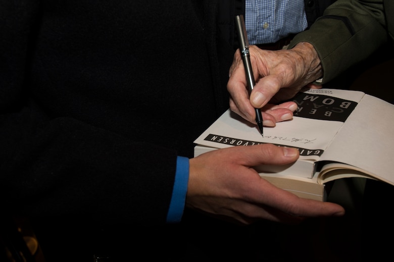 Retired U.S. Air Force Col. Gail Halvorsen, a C-52 Skymaster pilot also known as the Candy Bomber, signs a book after the reopening ceremony of the Berlin Airlift Memorial outside Frankfurt International Airport, Germany, Nov. 22, 2016. Halvorsen and his fellow pilots dropped 23 tons of candy with makeshift parachutes from his C-54 as part of the Berlin Airlift, which delivered more than two million tons of food to the blockaded citizens of West Berlin between June 1948 and September 1949. (U.S. Air Force photo by Staff Sgt. Joe W. McFadden)