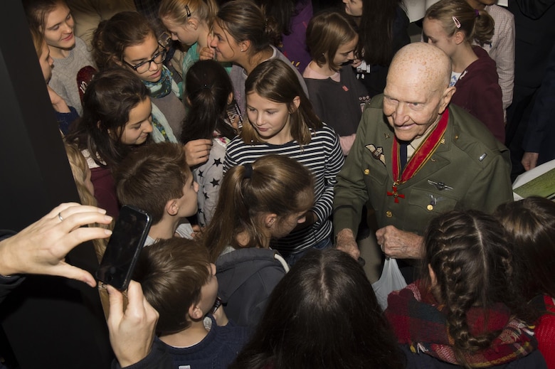 Retired U.S. Air Force Col. Gail Halvorsen, a C-52 Skymaster pilot also known as the Candy Bomber, hands out chocolate bars to German children after the reopening ceremony of the Berlin Airlift Memorial outside Frankfurt International Airport, Germany, Nov. 22, 2016. Halvorsen and his fellow pilots dropped 23 tons of candy with makeshift parachutes from his C-54 as part of the Berlin Airlift, which delivered more than two million tons of food to the blockaded citizens of West Berlin between June 1948 and September 1949. (U.S. Air Force photo by Staff Sgt. Joe W. McFadden)