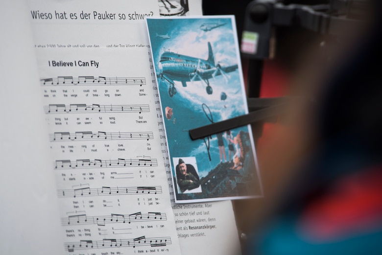A signed picture representing the Berlin Airlift rests on a music stand during the reopening ceremony of the Berlin Airlift Memorial outside Frankfurt International Airport, Germany, Nov. 22, 2016. The ceremony included retired U.S. Air Force Col. Gail Halvorsen, also known as the Candy Bomber, who dropped 23 tons of candy with makeshift parachutes from his C-54 Skymaster as part of the humanitarian supply mission. The Berlin Airlift, also known as Operation Vittles, delivered more than two million tons of food to the blockaded citizens of West Berlin between June 1948 and September 1949. (U.S. Air Force photo by Staff Sgt. Joe W. McFadden)