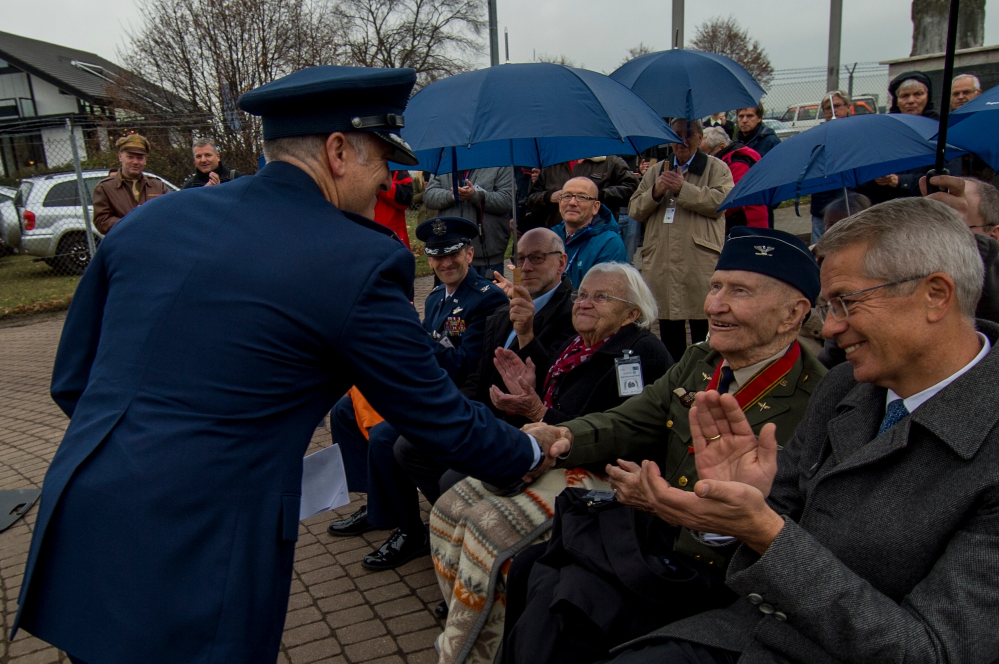U.S. Air Force Col. Timothy Stretch, U.S. Air Forces Europe representative on behalf of the commander, shakes the hand of retired U.S. Air Force Col. Gail Halvorsen, also known as the Candy Bomber, during the reopening ceremony of the Berlin Airlift Memorial outside Frankfurt International Airport, Germany, Nov. 22, 2016. Halvorsen and his fellow Airmen dropped 23 tons of candy with makeshift parachutes from his C-54 Skymaster as part of the humanitarian supply mission, which delivered more than two million tons of food to the blockaded citizens of West Berlin between June 1948 and October 1949. (U.S. Air Force photo by Staff Sgt. Joe W. McFadden)