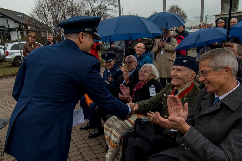 U.S. Air Force Col. Timothy Stretch, U.S. Air Forces Europe representative on behalf of the commander, shakes the hand of retired U.S. Air Force Col. Gail Halvorsen, also known as the Candy Bomber, during the reopening ceremony of the Berlin Airlift Memorial outside Frankfurt International Airport, Germany, Nov. 22, 2016. Halvorsen and his fellow Airmen dropped 23 tons of candy with makeshift parachutes from his C-54 Skymaster as part of the humanitarian supply mission, which delivered more than two million tons of food to the blockaded citizens of West Berlin between June 1948 and October 1949. (U.S. Air Force photo by Staff Sgt. Joe W. McFadden)