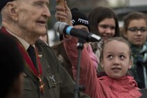 A German child holds up an umbrella for retired U.S. Air Force Col. Gail Halvorsen, a C-52 Skymaster pilot also known as the Candy Bomber, as he speaks during a reopening ceremony of the Berlin Airlift Memorial outside Frankfurt International Airport, Germany, Nov. 22, 2016. The children sang songs as part of the ceremony which commemorated the airlift which delivered more than two million tons of food to the blockaded citizens of West Berlin between June 1948 and October 1949. (U.S. Air Force photo by Staff Sgt. Joe W. McFadden)