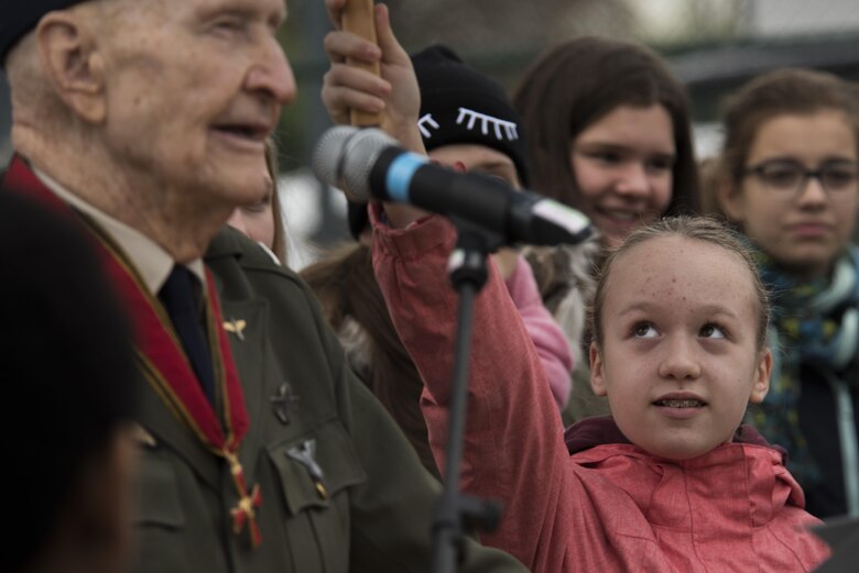 A German child holds up an umbrella for retired U.S. Air Force Col. Gail Halvorsen, a C-52 Skymaster pilot also known as the Candy Bomber, as he speaks during a reopening ceremony of the Berlin Airlift Memorial outside Frankfurt International Airport, Germany, Nov. 22, 2016. The children sang songs as part of the ceremony which commemorated the airlift which delivered more than two million tons of food to the blockaded citizens of West Berlin between June 1948 and October 1949. (U.S. Air Force photo by Staff Sgt. Joe W. McFadden)