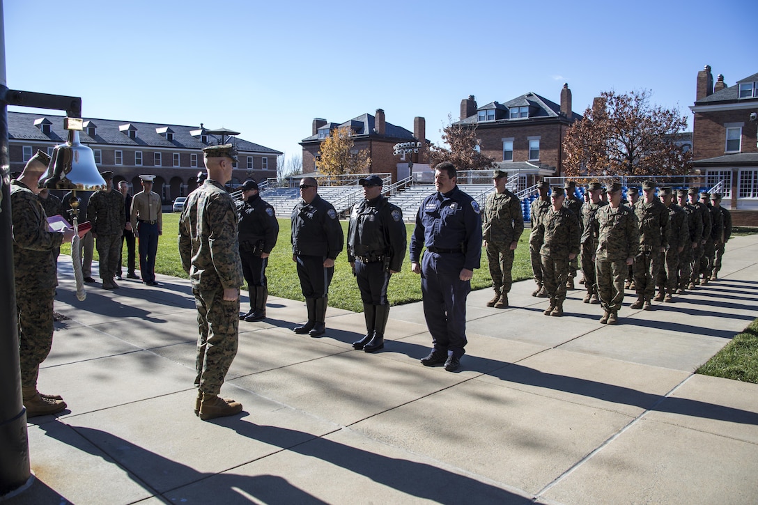 U.S. Marines with Guard Company, Marine Barracks Washington, D.C., and members of the Arlington County Police Department and D.C. Metropolitan Police Department stand at attention while citations are read for the officers during an award ceremony at the Barracks, Nov. 21, 2016. These officers were rewarded for supporting the Barracks Marines in protecting the thousands of guests, both civilian and military, that attend our annual parades.  (Official Marine Corps photo by Lance Cpl. Robert Knapp/Released)