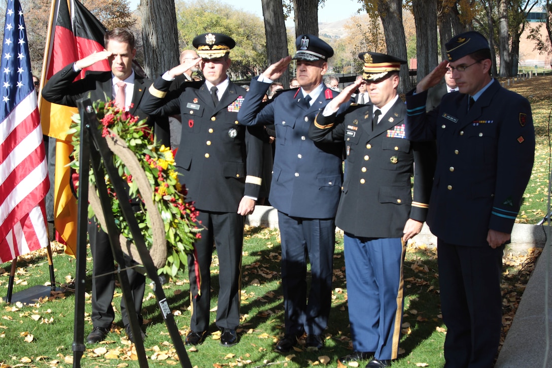 While most people celebrate Veteran’s Day weekend with families and friends, more than a hundred people came to Fort Douglas Military Cemetery November 13 to honor the 41 German prisoners of war (POW) who are buried here from both World Wars I and II.  
At the end of the Fort Douglas ceremony, the official party laid a ceremonial wreath at the foot of the monument that honors the fallen German Soldiers and Sailors.  This monument is a mass grave where 21 of the 41 German POWs are buried, located at the southwest corner of the Fort Douglas Cemetery.