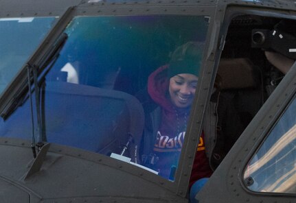 A football fan sits inside a U.S. Army Black Hawk from Bravo Company, 12th Aviation Battalion, prior to the start of the NFL's Military Appreciation game Nov. 20, at Fedex Field in Landover, Maryland. U.S. Army Reserve and Active Duty Military Police Soldiers showcased static displays of military vehicles and aircraft as well as military working dogs prior to the game. The 200th Military Police Command had several HMMWVs and an armored security vehicle on display, providing the public an opportunity to learn more about the MP career field. (U.S. Army Reserve photo by Sgt. Jennifer Spiker)