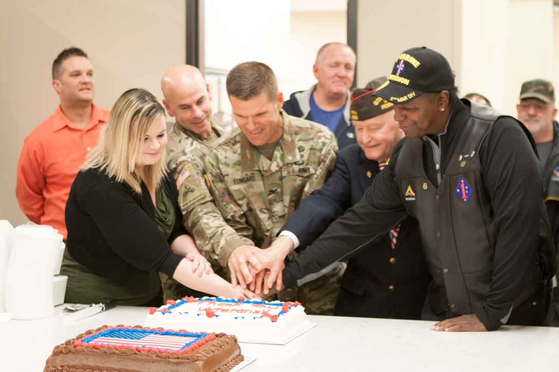 Army Col. Brad Eungard, commander of DLA Distribution Susquehanna, Pa., (center), Thomas A. Brown, the Pennsylvania commander of the Veterans of Foreign Wars (to Eungard’s right), and Army Col. David Shank from the United States Army War College in Carlisle, Pa., (to Eungard’s left), are joined by the most senior and most junior veteran during a cake cutting ceremony on Nov. 9.