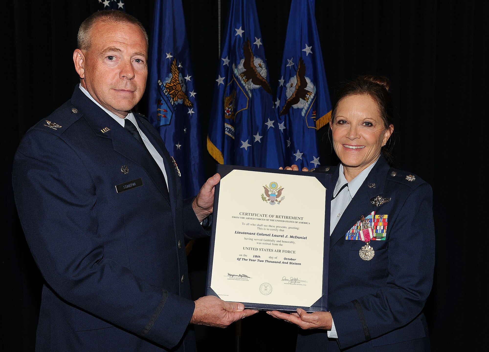 PETERSON AIR FORCE BASE, Colo. – Col. Robert Stanton, 302nd Operations Group commander, presents Lt. Col. Laurel McDaniel, 34th Aeromedical Evacuation Squadron commander, a retirement certificate on Nov. 5, 2016, here. McDaniel served 35 years and nine months in the U.S. Air Force Reserve. “It is important to embrace change because change builds character; our character comes from our Air Force core values,” said McDaniel. Her U.S. Air Force Reserve has been an “incredible journey.” In retirement, McDaniel plans to spend more time with her family, skiing, supporting the Denver Broncos, and advocating for Air Force Reserve members who are still serving. (U.S Air Force photo/Staff Sgt. Amber Sorsek)