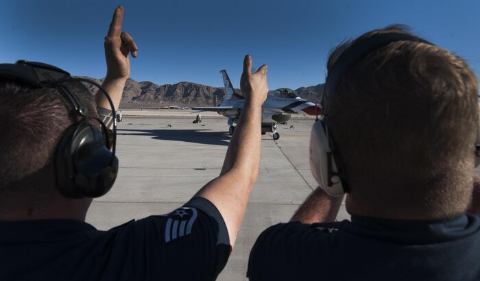 U.S. Air Force Thunderbird Air Demonstration Squadron crew chiefs cheer on a Thunderbird jet as it taxis down the runway during Aviation Nation on Nellis Air Force Base, Nev., Nov. 11, 2016. The Thunderbirds showcase the skill and precision of the aviators, maintenance and support Airmen who deploy to defend the nation and its allies. (U.S. Air Force photo by Airman 1st Class Kevin Tanenbaum/Released)