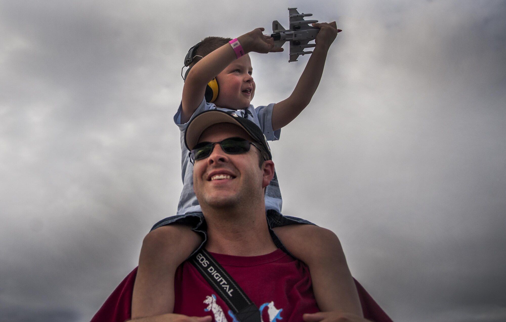 A young child sits on his father’s shoulders during the U.S. Air Force Thunderbirds Air Demonstration Squadron aerial performance at the Aviation Nation air show on Nellis Air Force Base, Nev., Nov. 12, 2016. This event marked the end of the air show season for the U.S. Air Force Air Demonstration Squadron, the Thunderbirds. (U.S. Air Force photo by Airman 1st Class Kevin Tanenbaum/Released)