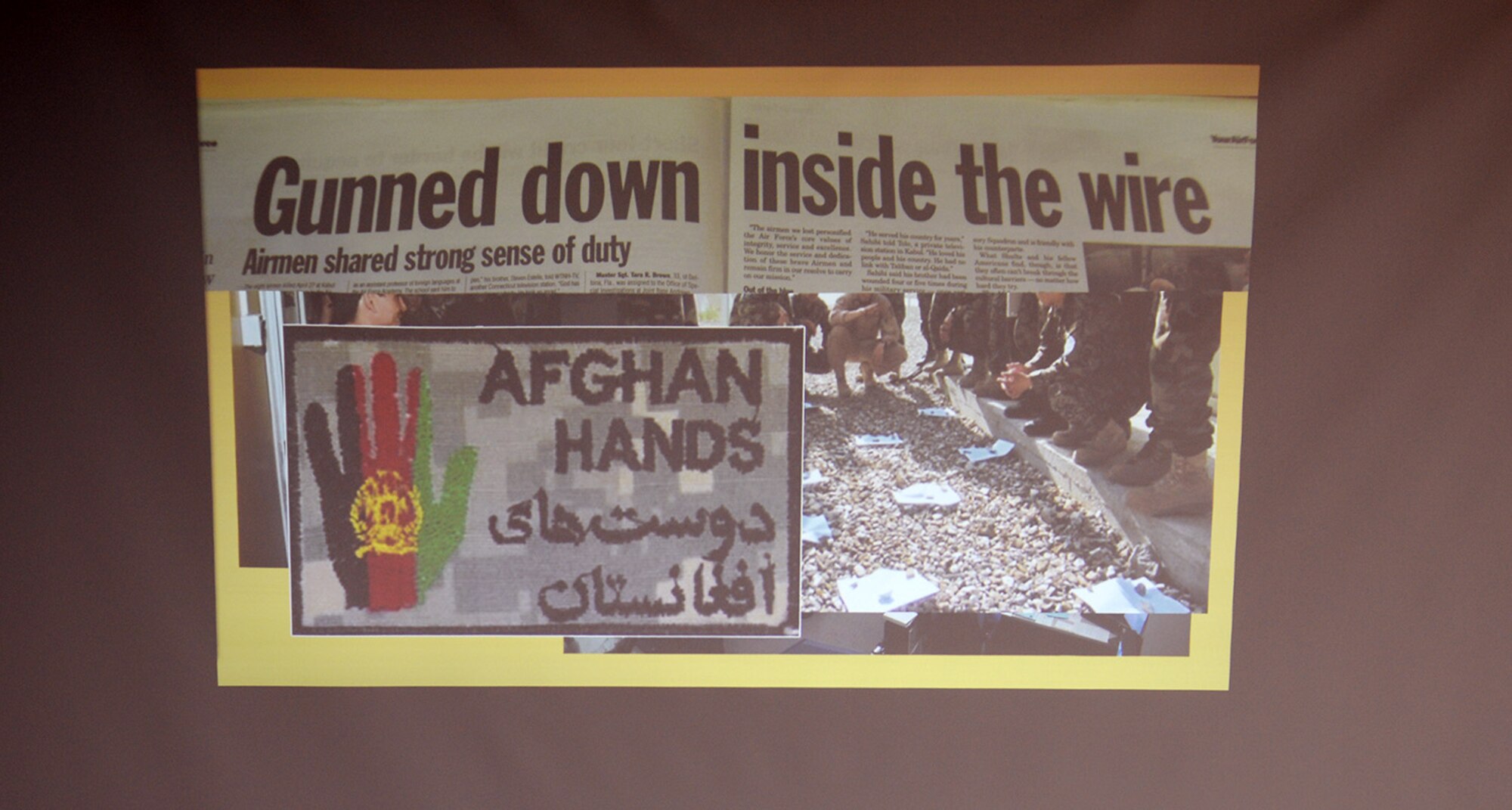 A copy of the Air Force Times newspaper forms part of a slideshow which shows the story of how a pilot and other military members were gunned down by an Afghan military member in April 2011, in Afghanistan, during a “Storytellers” event Nov. 18, 2016, on RAF Mildenhall, England. Storytellers was created to encourage Airmen to share their experiences and help others; it also serves as an avenue for Airmen to share their paths of resilience with others.  (U.S. Air Force photo by Karen Abeyasekere)