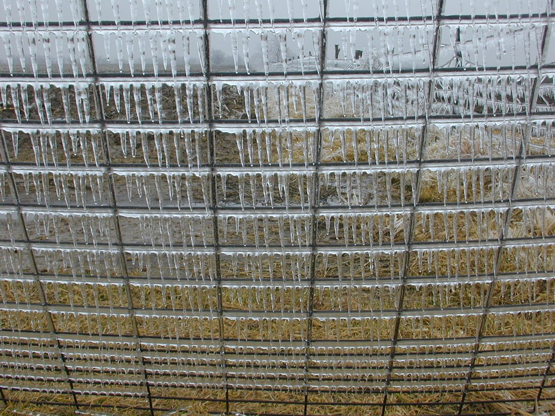 Glaze ice, formed by slow freezing rate, coating a fence.