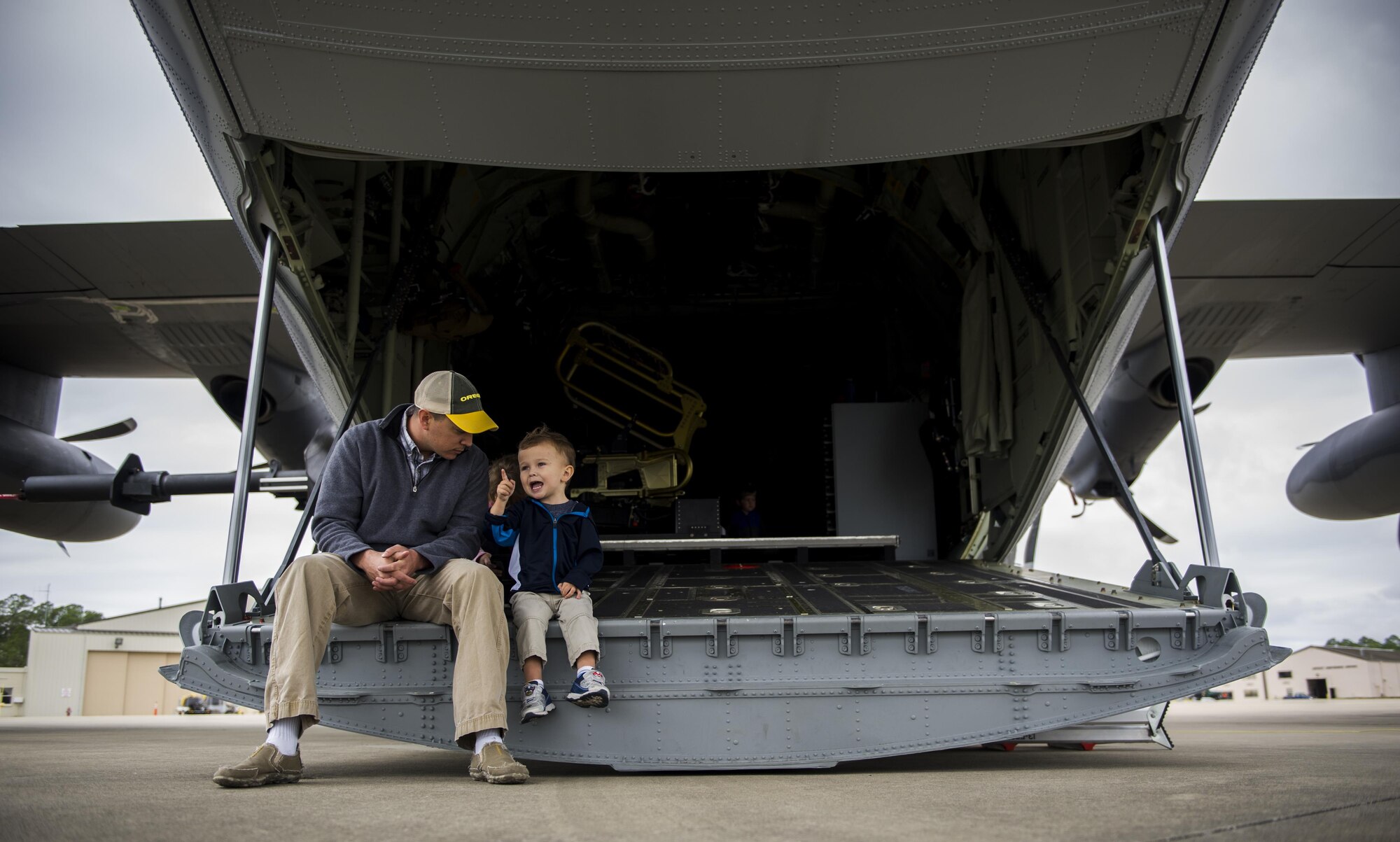 An Air Commando and his son sit on the back of an AC-130J Ghostrider gunship during a Spouses Flight tour at Hurlburt Field, Fla., Nov. 19, 2016. Before the flights began, spouse’s toured static displays of different aircraft to get a firsthand look at capabilities of the1st Special Operations Wing. (U.S. Air Force photo by Airman 1st Class Isaac O. Guest IV)