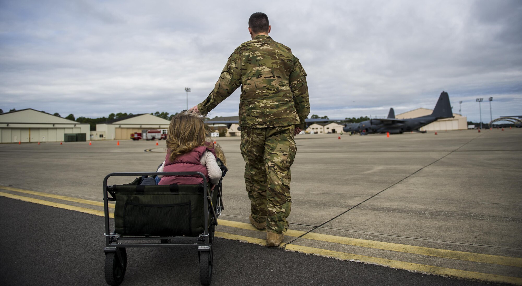 Capt. Mitchell Radigan, a flight doctor with the 1st Special Operations Medical Group, wheels his children to a static display during a Spouses Flight tour at Hurlburt Field, Fla., Nov. 16, 2016. Before the flights began, spouses toured different aircraft static displays to develop a better understanding of the importance of 1st Special Operations Wing mission. (U.S. Air Force photo by Airman 1st Class Isaac O. Guest IV)