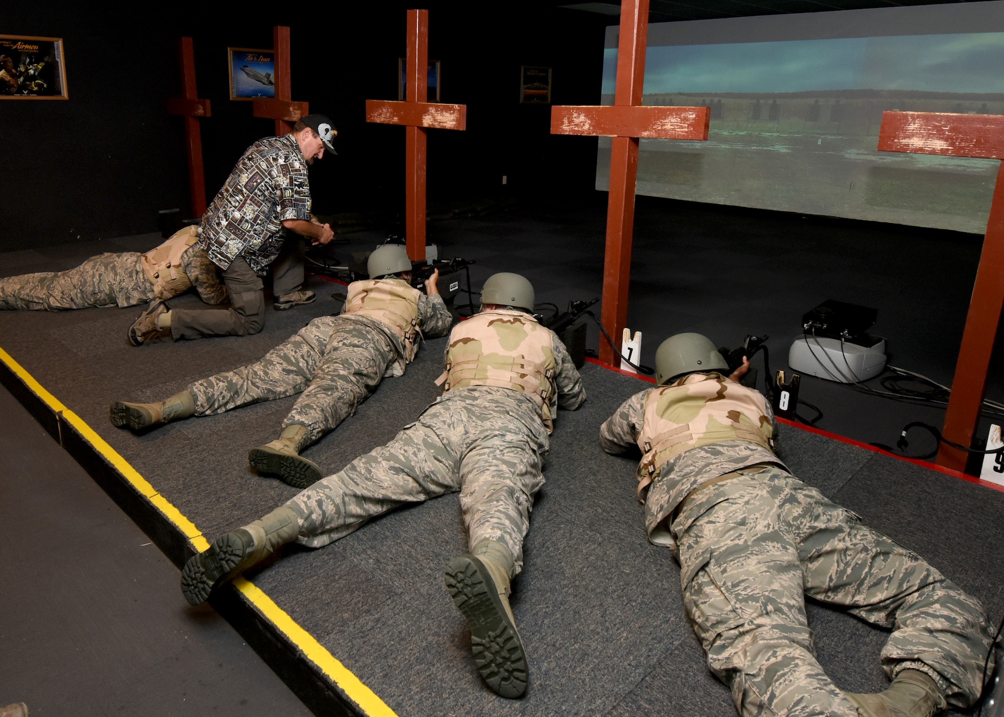 Herbert Estes, 97th Wing Staff Agencies expeditionary skills training instructor, help Airmen fire a simulated M-4 carbine properly during a pre-deployment course, Nov. 15, 2016, at Altus Air Force Base, Oklahoma. Before each Airman deploys out of Altus, they must first complete a pre-deployment class which teaches them to be proficient and confident in handling weapons and combat applicable skills. (U.S. Air Force photo by Senior Airman Nathan Clark/Released)