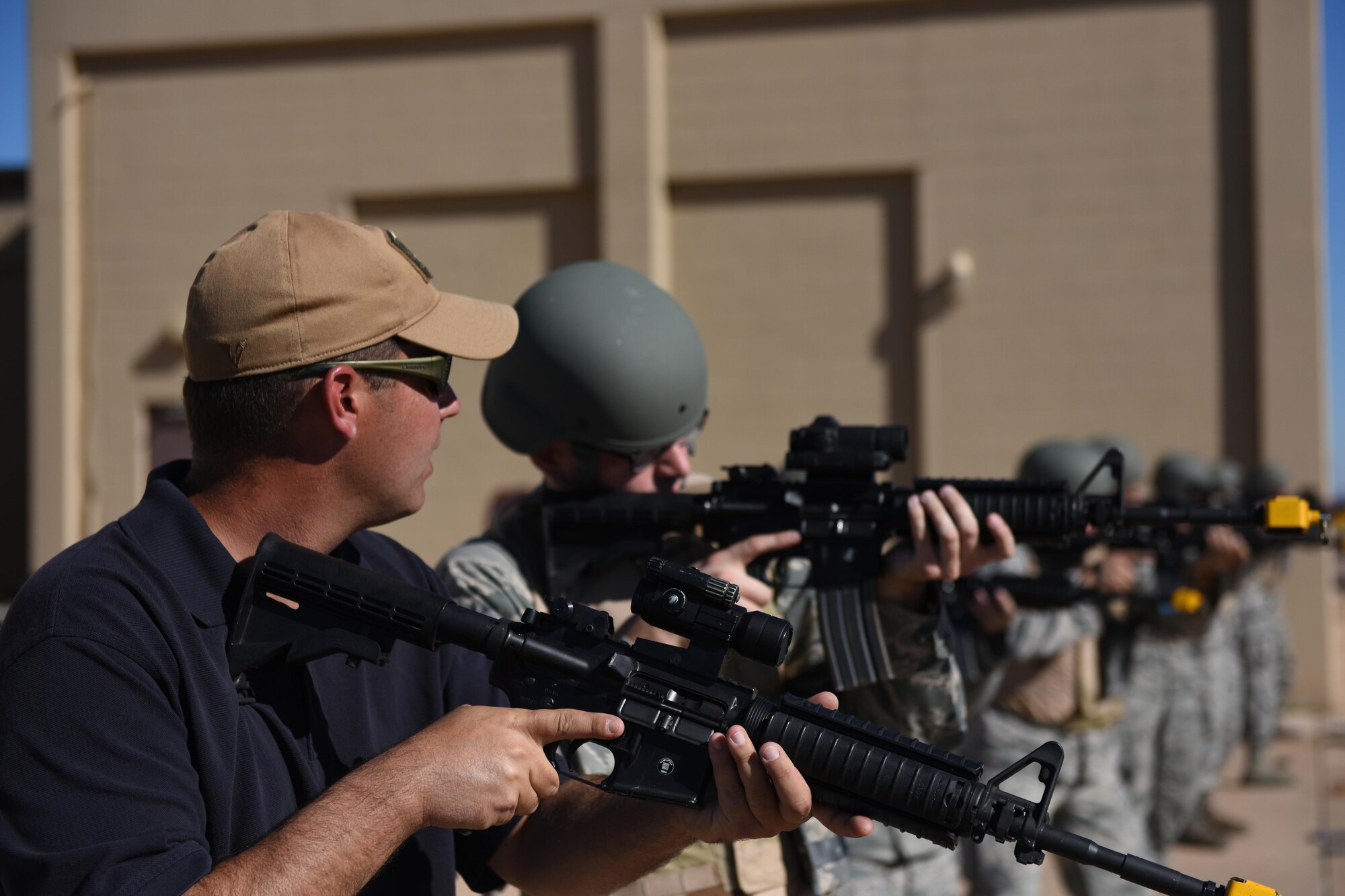 Nathan Dunnigan, 97th Wing Staff Agencies expeditionary skills training instructor, demonstrates a firing drill during a pre-deployment course, Nov. 15, 2016, at Altus Air Force Base, Oklahoma. Before each Airman deploys out of Altus, they must first complete a pre-deployment class which teaches them to be proficient and confident in handling weapons and combat applicable skills. (U.S. Air Force photo by Senior Airman Nathan Clark/Released)