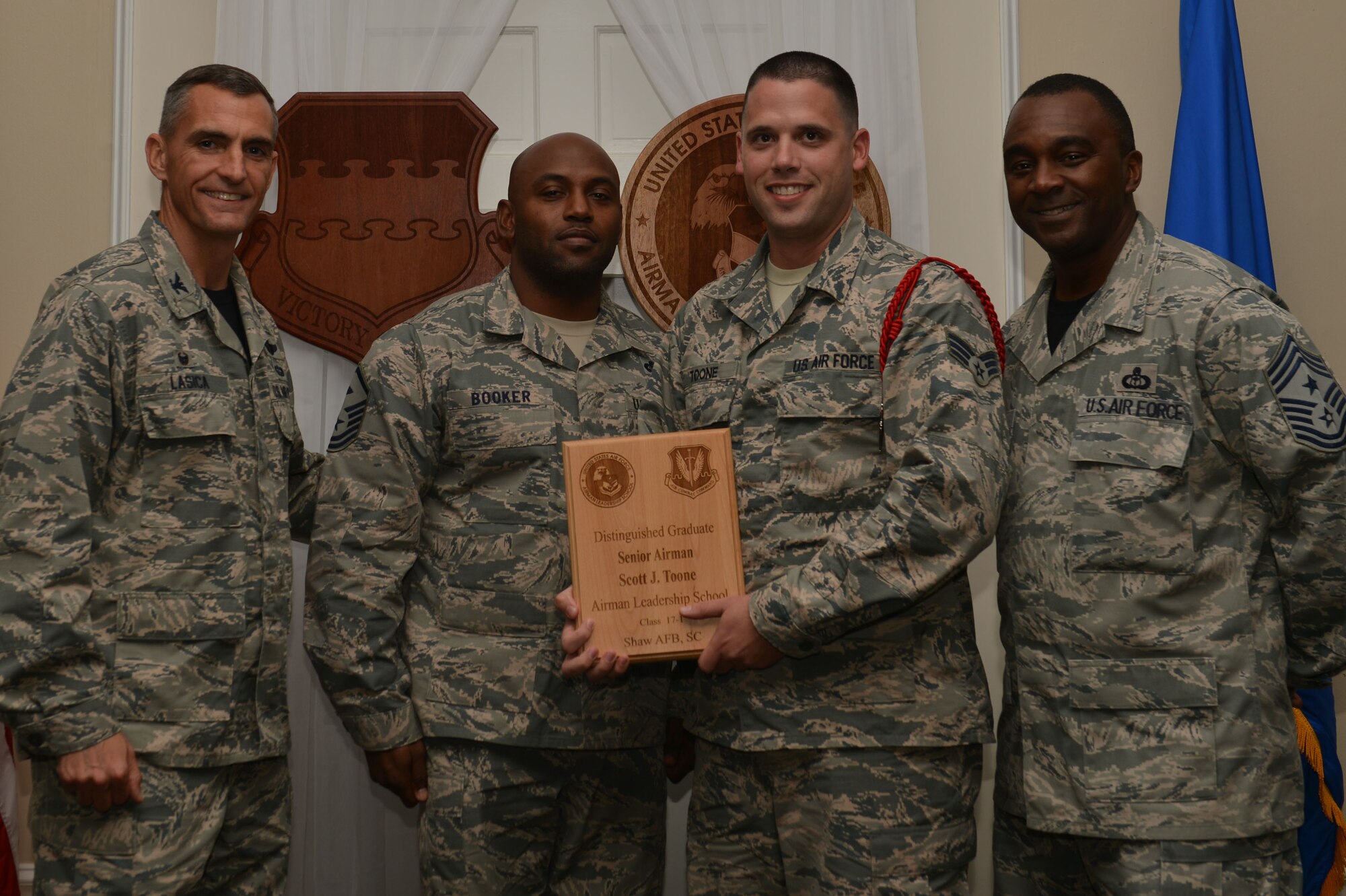 U.S. Air Force Senior Airman Scott Toone, 31st Intelligence Squadron, receives a distinguished graduate award for the Senior Master Sgt. David B. Reid Airman Leadership School Class 17-1 at Shaw Air Force Base, S.C., Nov. 18, 2016. The distinguished graduate awards are given to the top 10 percent of the class for total point accumulation. (U.S. Air Force photo by Airman 1st Class Christopher Maldonado)
