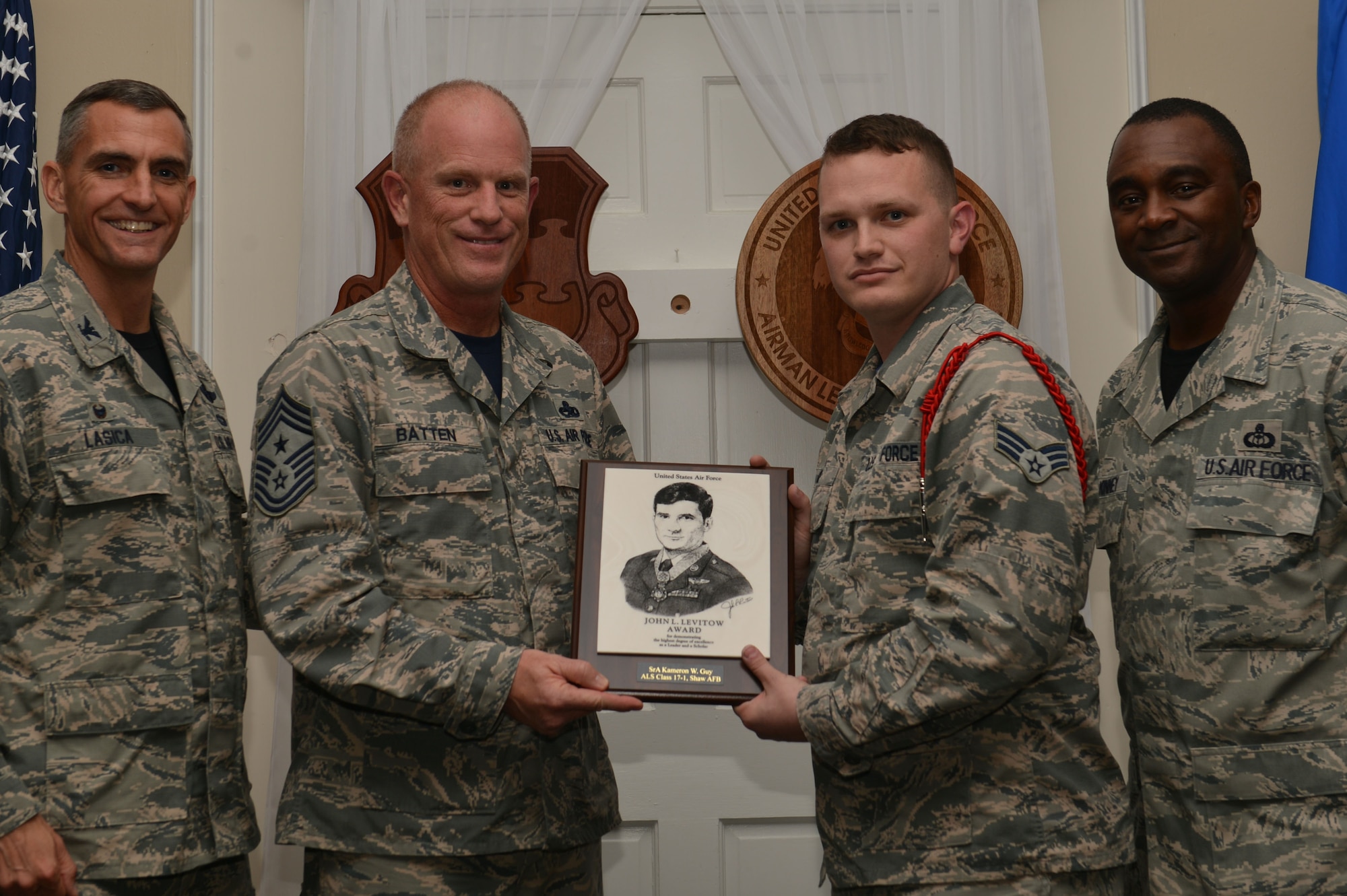U.S. Air Force Senior Airman Kameron Guy, 5th Intelligence Squadron, receives the John L. Levitow Award for the Senior Master Sgt. David B. Reid Airman Leadership School Class 17-1, from Chief Master Sgt. Frank Batten III, Ninth Air Force command chief, at Shaw Air Force Base, S.C., Nov. 18, 2016. The Levitow Award is given to the graduate with the highest average of instructor and student points, and is the highest award in enlisted professional military education. (U.S. Air Force photo by Airman 1st Class Christopher Maldonado)