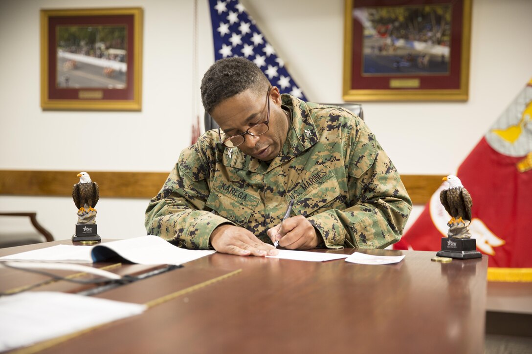 Col. Sekou Karega, Commanding Officer of Marine Corps Logistics Base Barstow, signs the first Combined Federal Campaign donation form to kick off MCLB Barstow campaign, Nov. 21, 2016. 