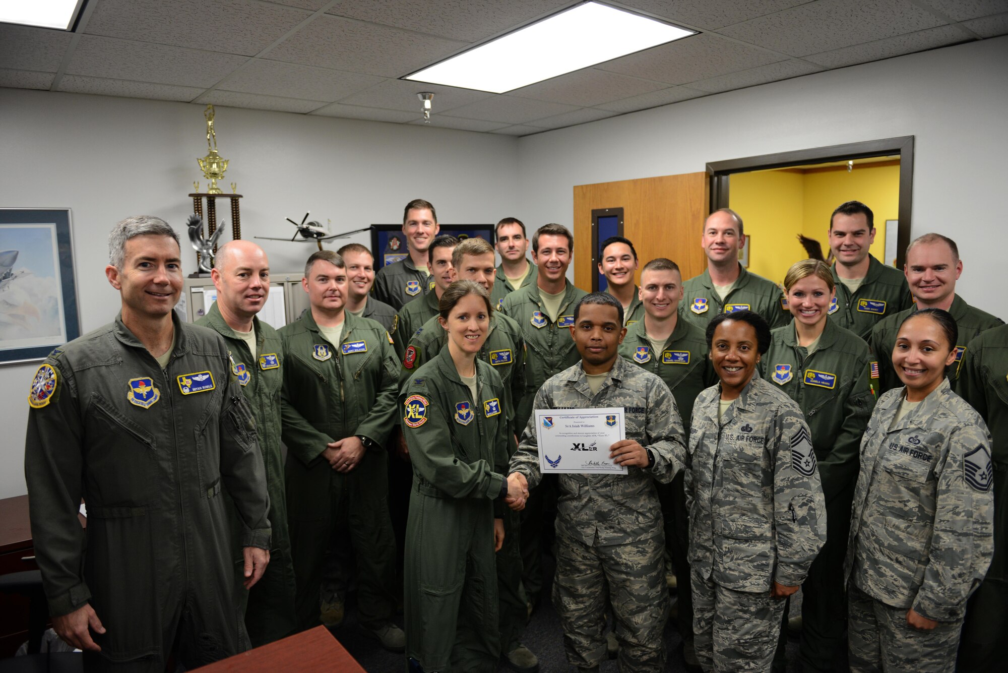 Senior Airman Isiah Williams, 85th Flying Training Squadron administrative journeyman (front center), accepts the “XLer of the Week” award from Col. Michelle Pryor (front left), 47th Flying Training Wing vice commander, and Chief Master Sgt. Erica Shipp (front right), 47th Mission Support Group superintendent, on Laughlin Air Force Base, Texas, Nov. 16, 2016. The XLer is a weekly award chosen by wing leadership and is presented to those who consistently make outstanding contributions to their unit and Laughlin. (U.S. Air Force photo/Airman 1st Class Benjamin N. Valmoja)