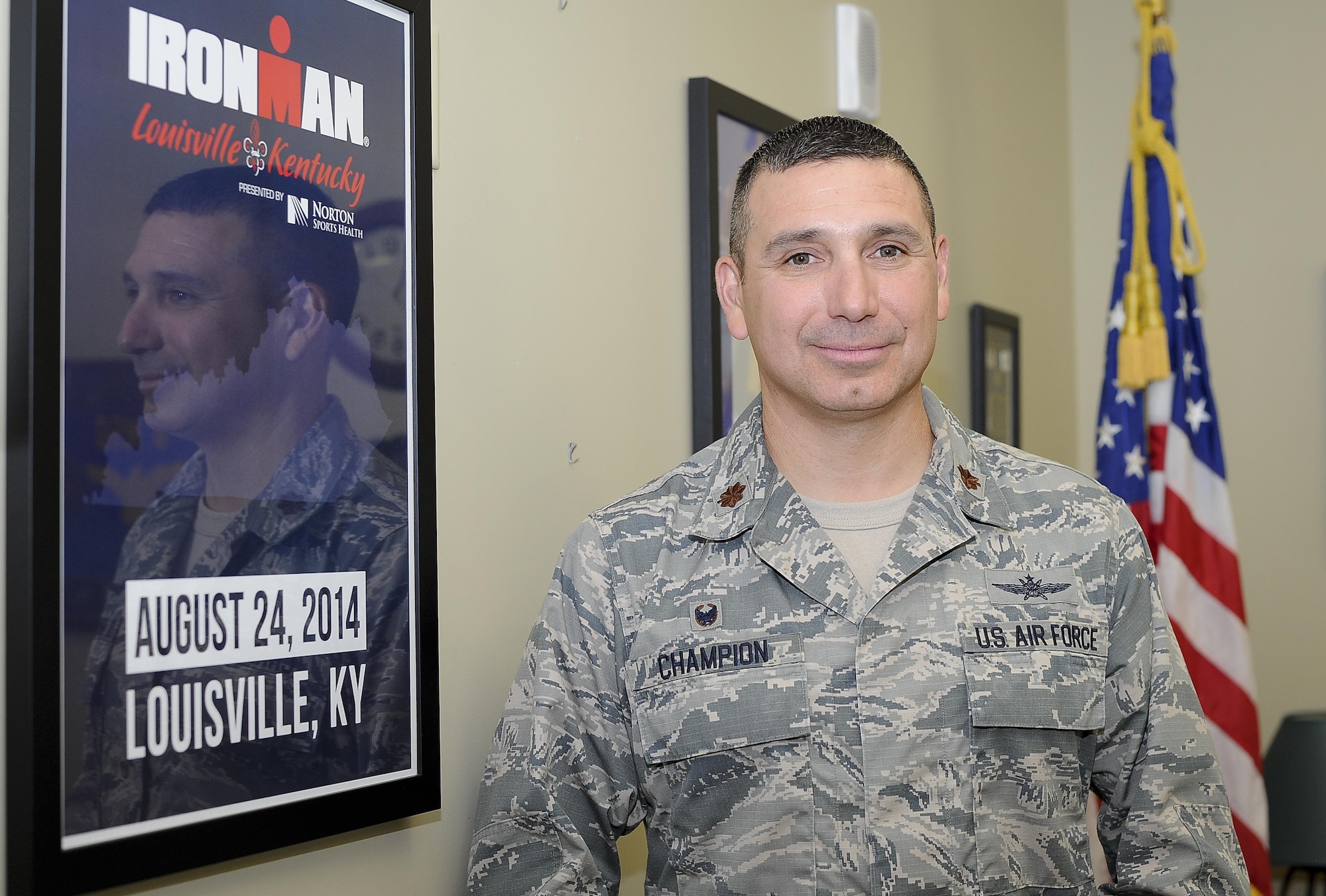 Maj. Reynaldo Champion, commander of the 6th Communications Squadron, pauses for a photo in front of an Ironman poster in his office at MacDill Air Force Base, Fla., Nov. 11, 2016. Champion has traveled all over the country and trains year-round to compete in the races he’s passionate about. (U.S. Air Force photo by Airman 1st Class Mariette Adams)