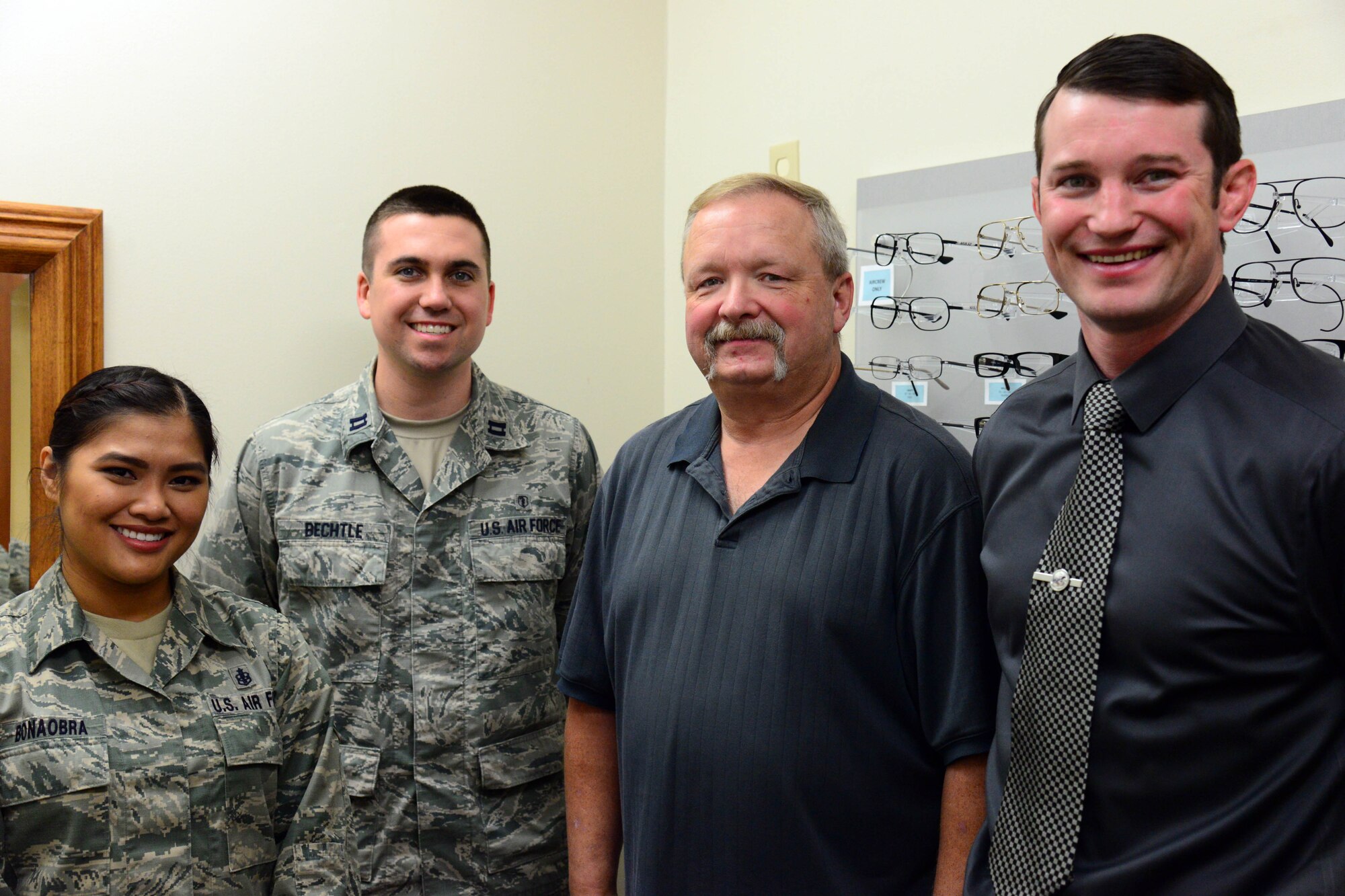 John Dresel, 341st Medical Operations Squadron optometry technician, center, poses for a photo with his optometry teammates, Nov. 2, 2016, at Malmstrom Air Force Base, Mont. The optometry clinic runs as smoothly as possible due to Dresel and his team providing customers with genuine customer care and a smile. (U.S. Air Force photo/Airman 1st Class Magen M. Reeves)