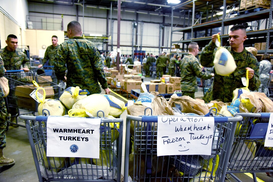 Marines load turkeys into carts at the start of Operation Warmheart inside the commissary on Goodfellow Air Force Base, Texas, Nov. 22, 2016. Volunteers filled care boxes with Thanksgiving food and gave them to service members for the holiday. (U.S. Air Force photo by Senior Airman Joshua Edwards/Released)