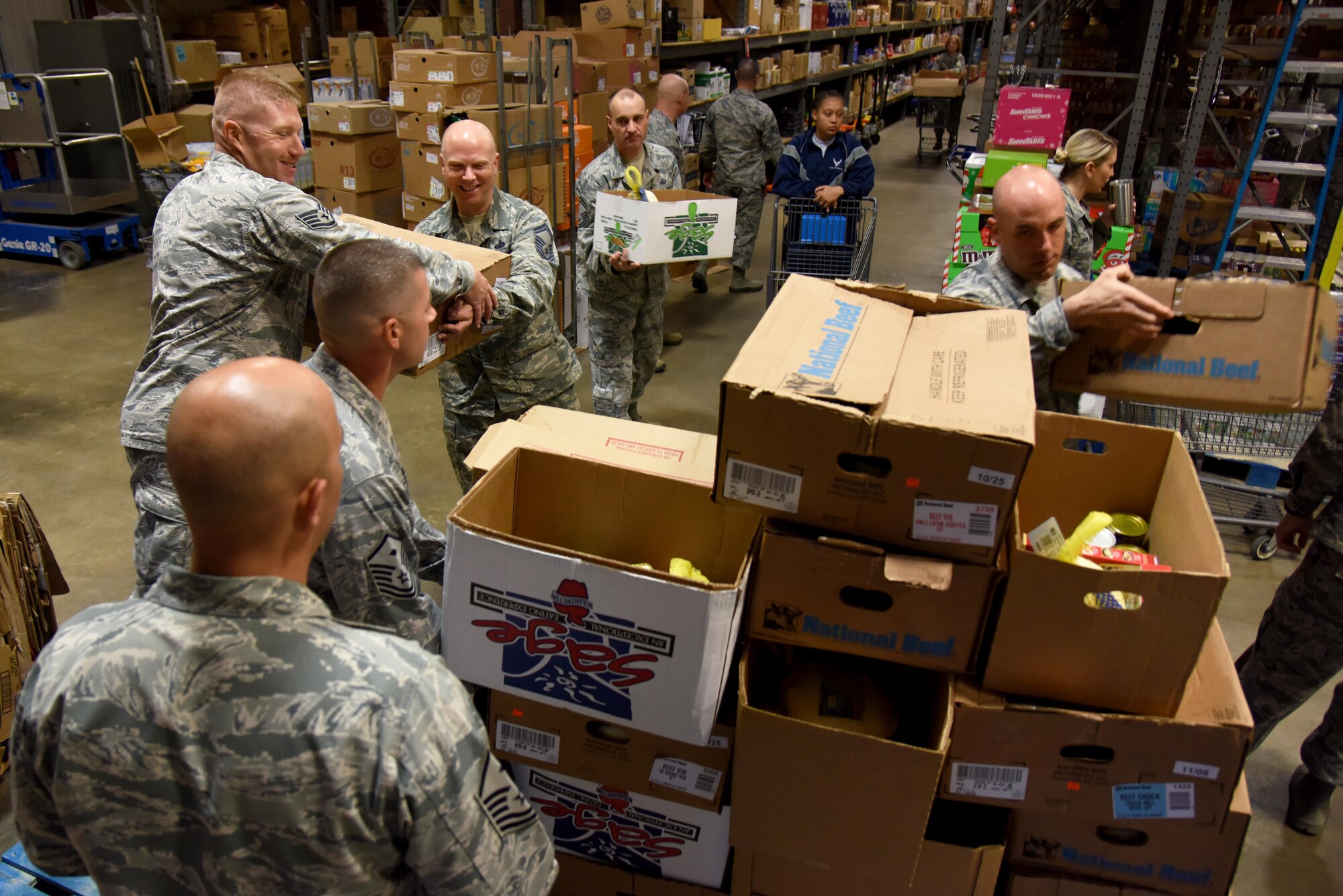 Airmen load filled boxes for Operation Warmheart onto a cart inside the commissary on Goodfellow Air Force Base, Texas, Nov. 22, 2016. The Goodfellow First Sergeant Association gave the boxes, which held a whole turkey and various non-perishable items, to 212 service members for Thanksgiving. (U.S. Air Force photo by Senior Airman Joshua Edwards/Released)