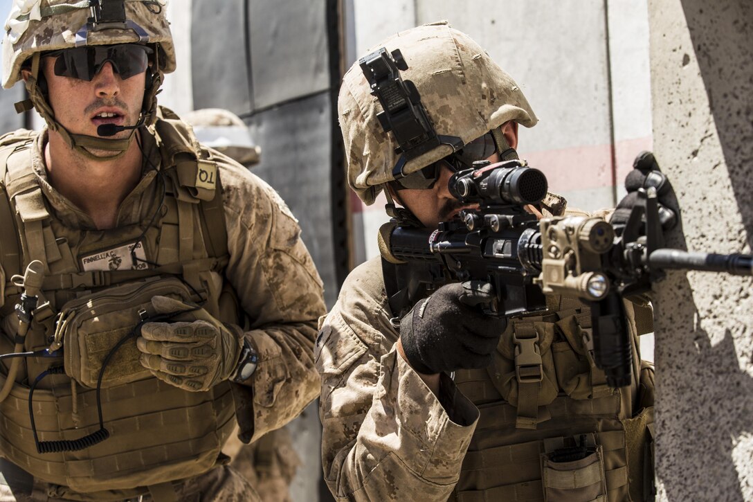 1st Lt. Austin Finnell (left) and Cpl. Jon Philips peer through an opening while conducting a raid during the 11th Marine Expeditionary Unit’s Combined Arms Exercise at Marine Corps Air Ground Combat Center Twentynine Palms, Calif., June 12, 2016. A raid is an operation, usually small scale, involving a swift penetration of hostile territory to secure information, confuse the enemy, or to destroy his installations. MEUCAX is conducted to maintain a high level of combat readiness prior to the 11th MEU’s Western Pacific 16-2 deployment later this year. Finnell is an infantry officer and Philips is a light armored vehicle repairer; both are with LAR Company, Battalion Landing Team 1st Bn., 4th Marines, 11th MEU. (U.S. Marine Corps photo by Lance Cpl. Zachery Laning/Released)
