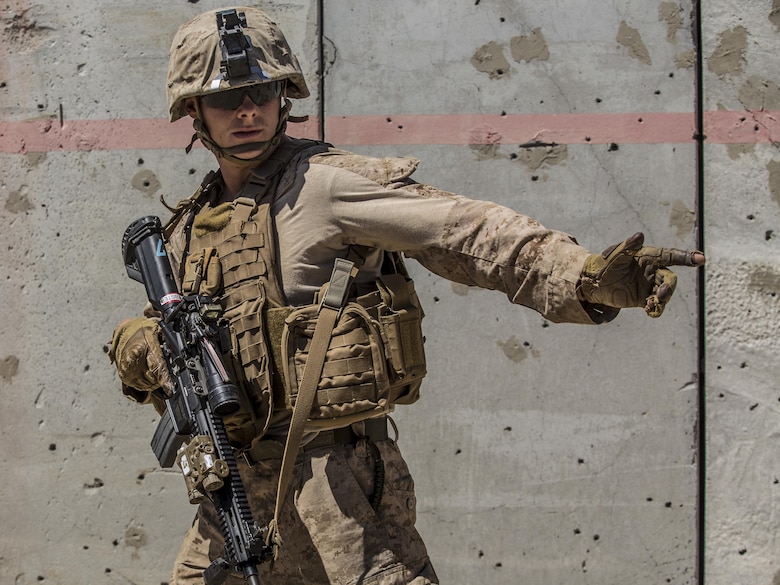 Lance Cpl. Michael Webster signals to his team while conducting a raid during the 11th Marine Expeditionary Unit’s Combined Arms Exercise at Marine Corps Air Ground Combat Center Twentynine Palms, Calif., June 12, 2016. MEUCAX enables Battalion Landing Team 1st Battalion, 4th Marines to refine their offensive and defensive tactics at the company and battalion levels. This training enables the Marines to practice transitioning from an offensive attack to the defense position, both during day and night operations. The culminating event will involve a battalion ground offensive in coordination with Marine aviation close-air support. MEUCAX is conducted to maintain a high level of combat readiness prior to the MEU’s Western Pacific 16-2 deployment later this year. Webster is a rifleman with LAR Company, Battalion Landing Team 1st Bn., 4th Marines, 11th MEU. (U.S. Marine Corps photo by Lance Cpl. Zachery Laning/Released)