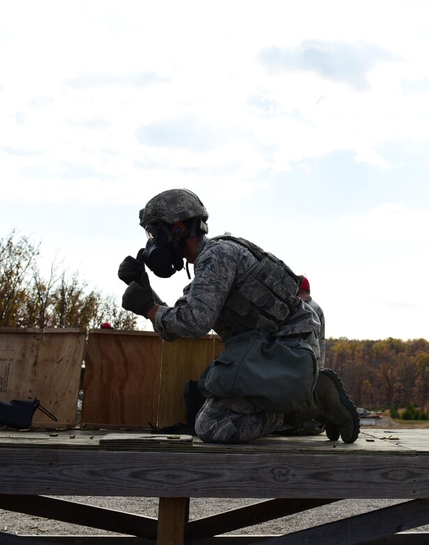U.S. Air Force Airman 1st Class James Ballard, a 509th Security Forces Squadron security response team member, secures an M50 gas mask prior to firing an M249 automatic rifle at Fort Leonard Wood, Mo., Nov. 14, 2016. Airmen practice firing with a gas mask and with thermal scopes for familiarization purposes.