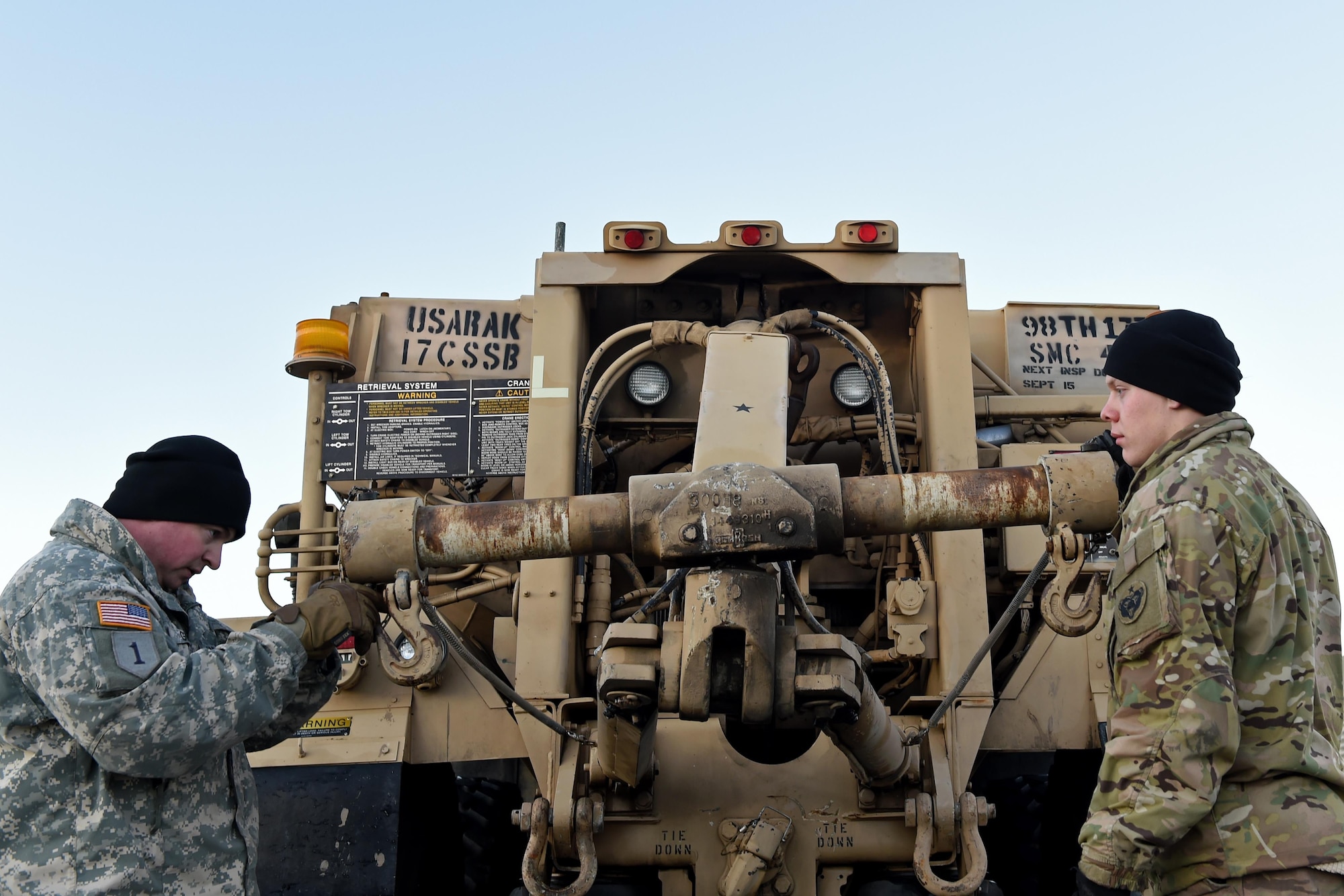 Spc. Damien Gille, wrecker support, and Spc. Kelly Fugate, wheeled vehicle mechanic with the 98th Support Maintenance Company, 17th Combat Sustainment Support Battalion, U.S. Army Alaska, ensure the serviceability of the Heavy Expanded Mobility Tactical Truck A4 Recovery Truck, near the 773d Logistics Readiness Squadron Movement Control Center at Joint Base Elmendorf-Richardson, Alaska, Nov. 15, 2016. Cargo processed through the MCC will be shipped to the National Training Center at Fort Irwin, Calif.