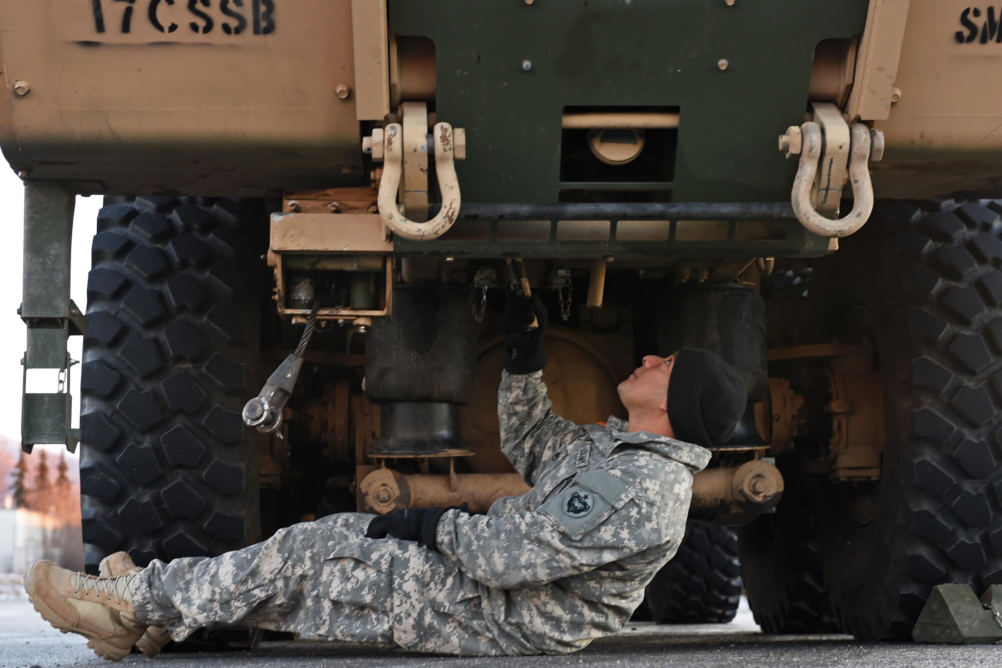 Army Staff Sgt. Rudy Flores, 98th Support Maintenance Company, 17th Combat Sustainment Support Battalion, a U.S. Army Alaska Headquarters platoon sergeant, inspects the bottom of a Heavy Expanded Mobility Tactical Truck A4 Recovery Truck at the 773d Logistics Readiness Squadron Movement Control Center at Joint Base Elmendorf-Richardson, Alaska, Nov. 15, 2016. Cargo processed through the MCC will be shipped to the National Training Center at Fort Irwin, Calif. 
