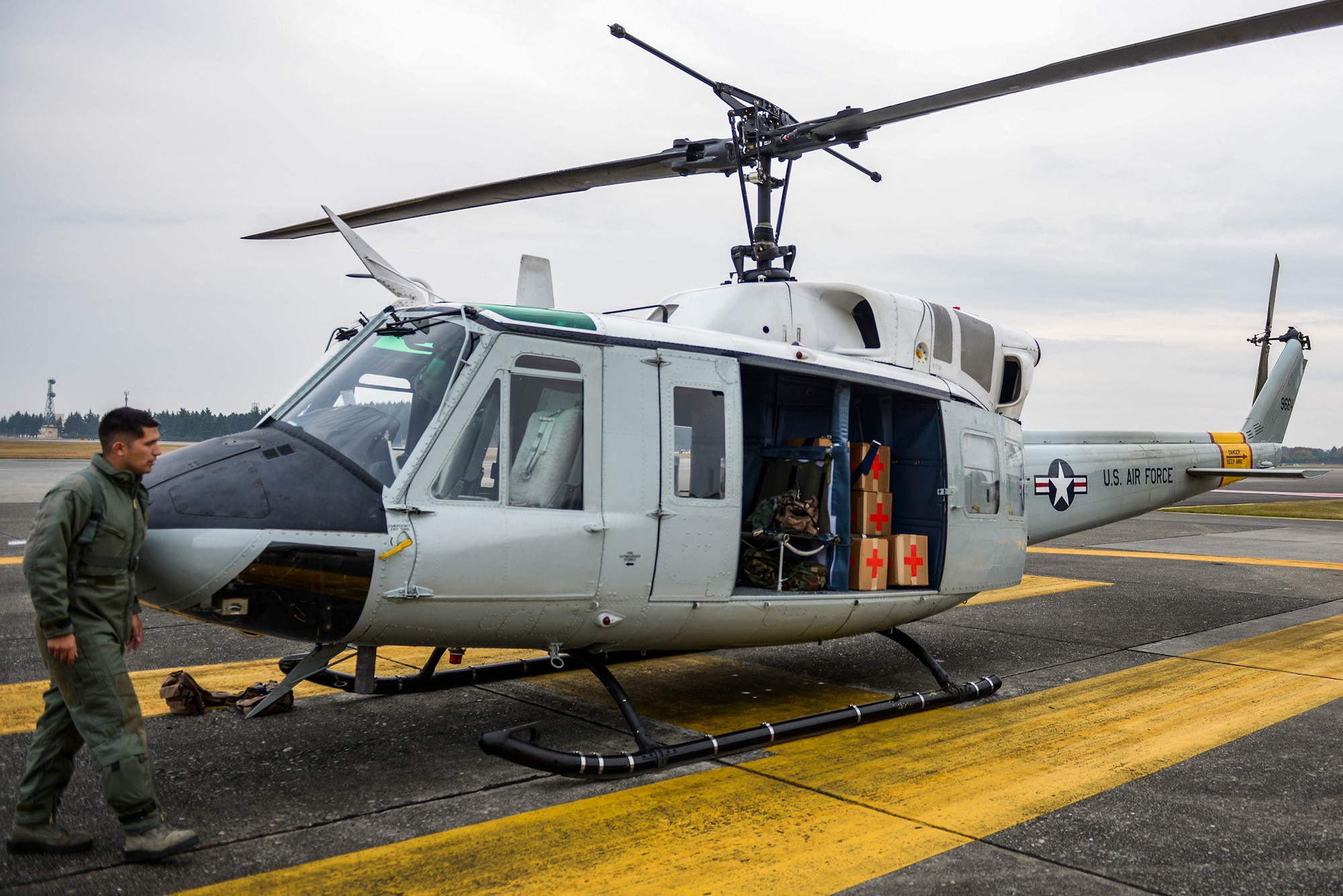 Capt. Vicente Vasquez, 459th Airlift Squadron UH-1N Iroquois instructor pilot, surveys the aircraft before takeoff Nov. 21, 2016, at Yokota Air Base, Japan during a Tokyo Metropolitan Government Comprehensive Disaster Management Drill. The 459 AS, Japan Self-Defense Forces, U.S. Army and U.S. Navy practiced delivering simulated relief supplies to Oshima Island. (U.S. Air Force  photo by Senior Airman Justin Carnahan/Released)