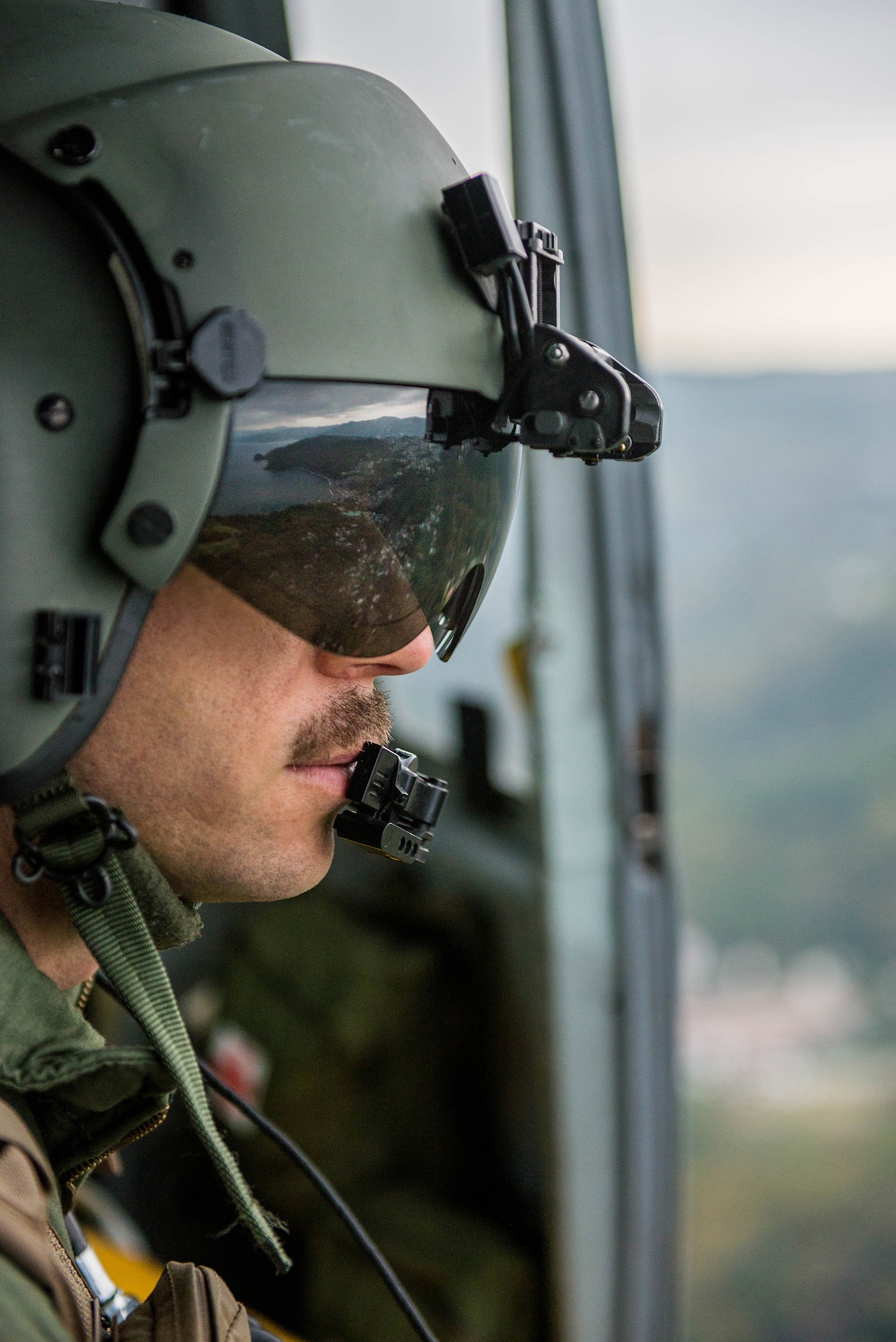 Staff Sgt. Nicholas Poe, 459th Airlift Squadron UH-1N Iroquois flight engineer, looks out over the Japanese coastline Nov. 21, 2016. Yokota’s 459 AS worked with the Japan Self-Defense Forces, U.S. Army and U.S. Navy on an exercise to deliver simulated humanitarian aid to Oshima Island, Japan, after a volcanic eruption. (U.S. Air Force  photo by Senior Airman Justin Carnahan/Released)