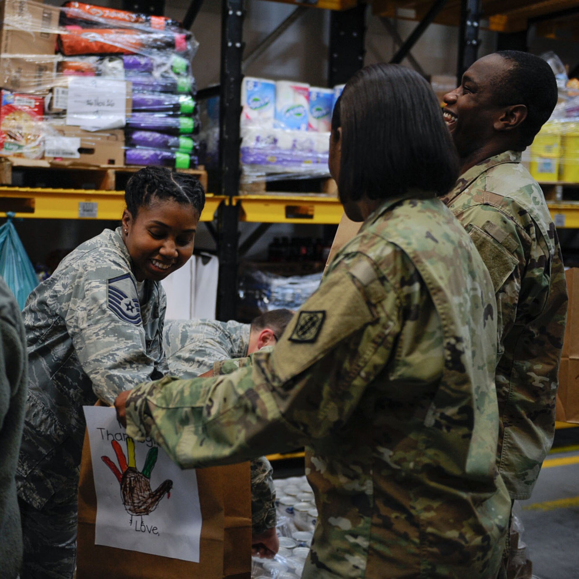 Master Sgt. Phyllis Brooks, 1st Combat Communications Squadron combat operations section chief, fills a bag with supplies for the Thanks for Thanksgiving event at Vogelweh Air Base. Germany, Nov. 19, 2016. Students from surrounding Kaiserslautern Military Community elementary schools decorated brown bags with feathers and drawings of turkeys. Each package included a 10-12 lb. frozen turkey, a roasting pan, stuffing mix, gravy, cranberry sauce, mashed potatoes, vegetables, yams, dinner rolls, a frozen pie, and a $25 Visa gift card. (U.S. Air Force photo by Airman 1st Class Savannah L. Waters)