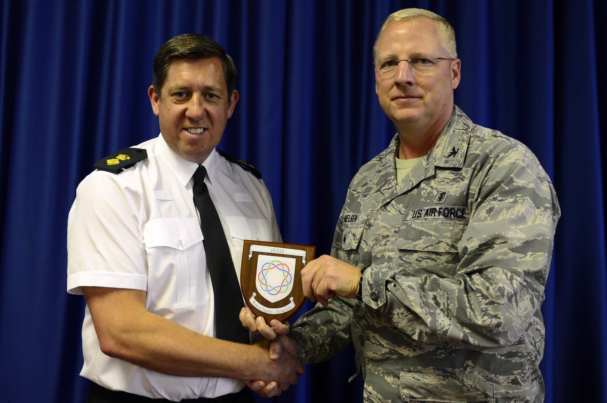 Carl Daniels, Joint Emergency Services Interoperability Principles deputy responsible officer, presents Col. Bradley Nielsen, 48th Medical Group deputy commander, with a token of appreciation during the JESIP presentation at Royal Air Force Lakenheath, England, Nov. 17. The 48th MDG plans to continue these presentations annually, while expanding the training into a joint practical application exercise that will be mutually beneficial for both U.S. and U.K. participants. (U.S. Air Force photo/ Senior Airman Malcolm Mayfield)
