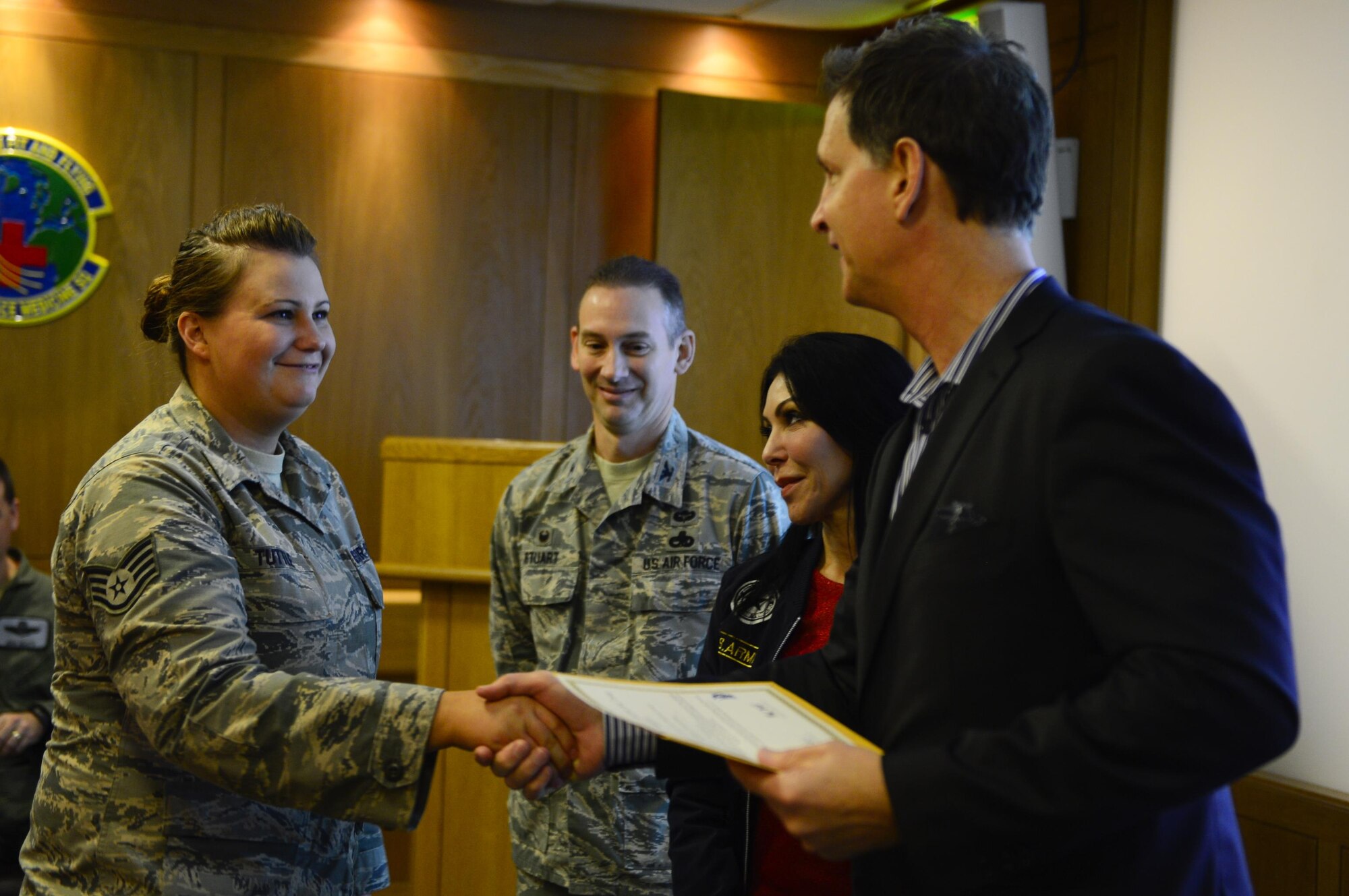 Tom Burkett, Troop Rewards director, shakes hands with a 48th Fighter Wing Airman, Nov. 21, at Royal Air Force Lakenheath, England. Ten Airmen and their families were received all-expenses-paid family vacations to one of 14 resorts in the U.S. (U.S. Air Force photo/Senior Airman Malcolm Mayfield)