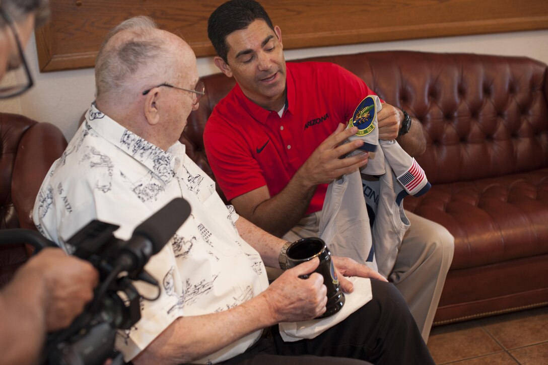 James Francis, University of Arizona senior associate director of athletics, shows Lauren Bruner, one of six living survivors of the Dec. 7, 1941 Japanese attack on the battleship USS Arizona at Pearl Harbor, Hawaii, a commemorative jersey to be worn by the UA Wildcats football team in Tucson, Ariz., Sept. 16, 2016. Bruner was honored throughout the Arizona Wildcats versue Hawaii Rainbow Warriors football game commemorating the 75th anniversary of the Pearl Harbor attacks. Air Force photo by Senior Airman Chris Drzazgowski