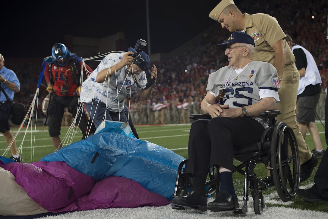 A photographer gets tangled in a parachutist’s suspension lines while Lauren Bruner, survivor of the Dec. 7, 1941 attacks on Pearl Harbor, Hawaii, is assisted to the center of Arizona Stadium in Tucson, Sept. 17, 2016. Bruner was honored throughout the Arizona Wildcats versus Hawaii Rainbow Warriors football game commemorating the 75th anniversary of the Japanese attacks on Pearl Harbor. Air Force photo by Senior Airman Chris Drzazgowski