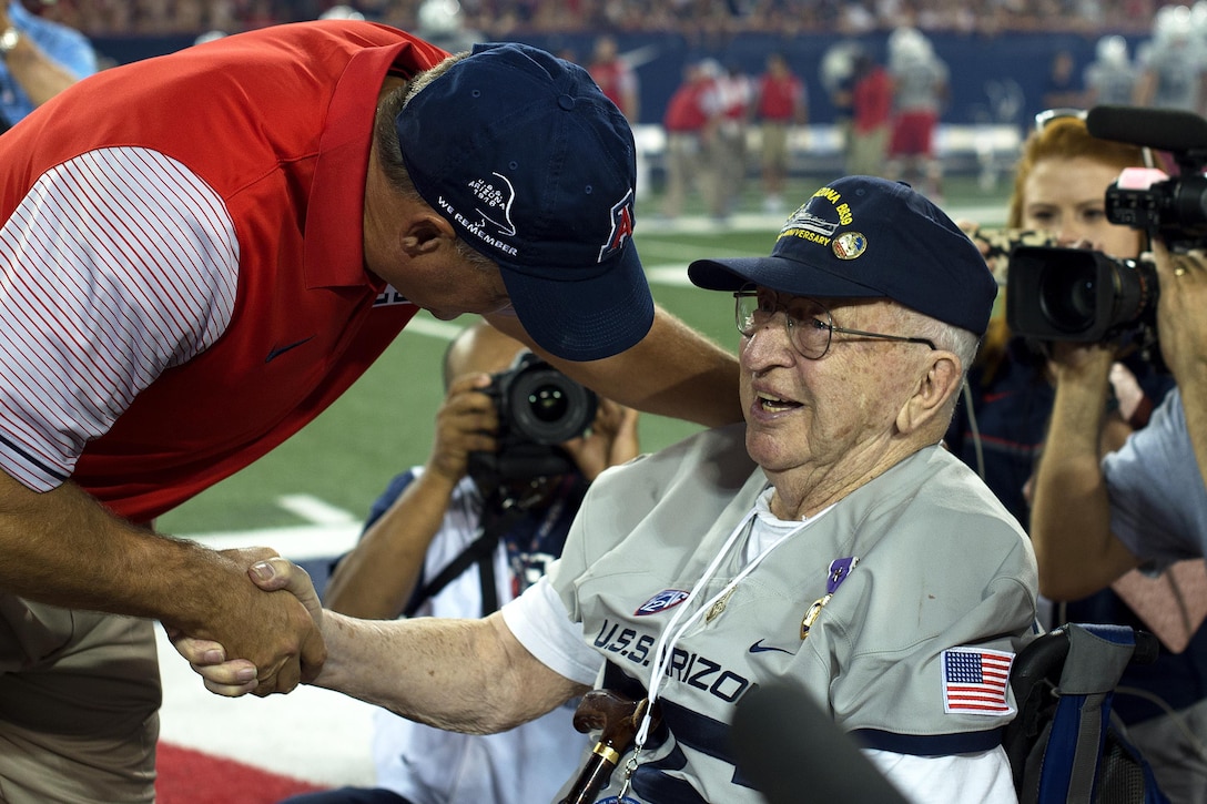 Rich Rodriguez, head coach of the Arizona Wildcats football team, shakes hands with Lauren Bruner, survivor of the Dec. 7, 1941 attacks on Pearl Harbor, Hawaii, at Arizona Stadium in Tucson, Sept. 17, 2016. Bruner was honored throughout the Arizona Wildcats versus Hawaii Rainbow Warriors football game commemorating the 75th anniversary of the Japanese attacks on Pearl Harbor. Air Force photo by Senior Airman Chris Drzazgowski