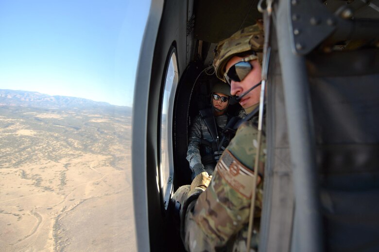 Tech. Sgt. Andy Moore, 13th Air Support Operations Squadron Joint Terminal Attack Controller, and Senior Airman Darion Badillo-Manzanares, 3rd Space Operations Squadron Satellite Vehicle Operator instructor, prepare to engage as they fly to the range at Fort Carson, Colorado, Wednesday, Nov. 9, 2016. Immediately as the UH-60 Blackhawk landed, the 13 ASOS and 3 SOPS members were ready for action. (U.S. Air Force photo/Dennis Rogers)