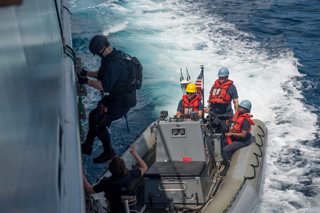 A USS McCampbell sailor disembarks the Royal Brunei Navy ship KDB Darussalam to board a rigid hull inflatable boat during a visit, board, search and seizure training exercise in the South China Sea, Nov. 17, 2016, as part of Cooperation Afloat Readiness and Training 2016. Navy photo by Petty Officer 2nd Class Christian Senyk