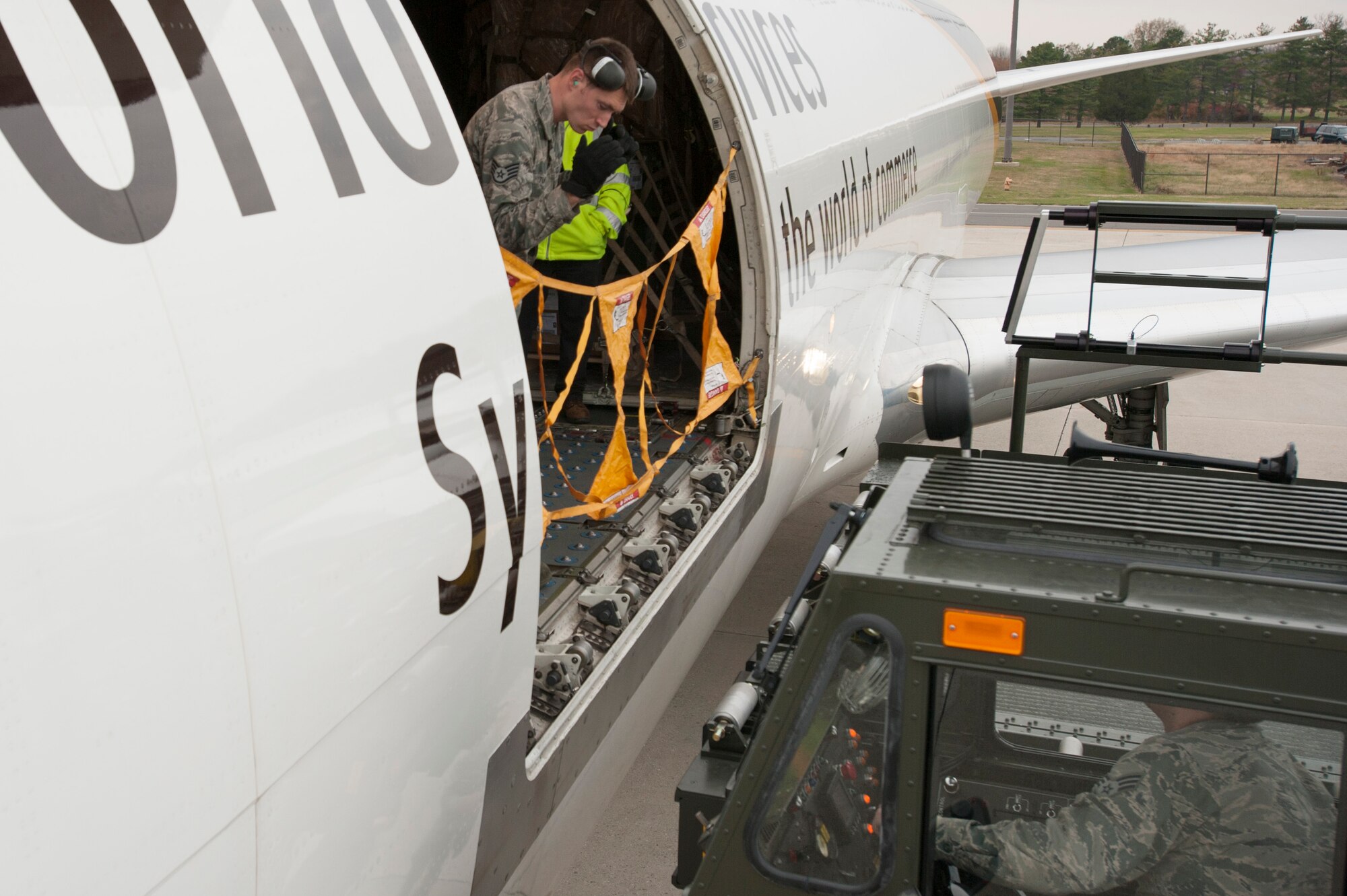 A member of the 305th Aerial Port Squadron guides a Tunner 60K Aircraft Loader into place on Nov. 16 at Joint Base McGuire-Dix Lakehurst, N.J. Engineers with DRS Technologies, along with AMC and 305 APS personnel conducted initial testing of a prototype rail extension system on the Tunner 60K Aircraft Loader here. The rail system is designed to extend during cargo loading and unloading to mitigate personnel fall risk. 